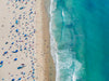 Color aerial photo of Manhattan Beach in Los Angeles with beach umbrellas, two lifeguard towers and the ocean