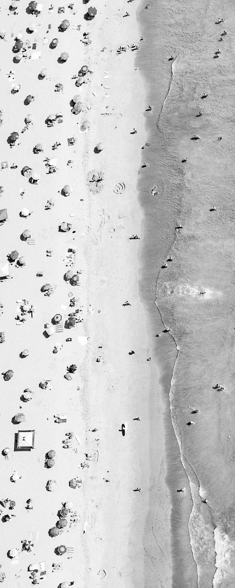 Vertical panoramic black and white aerial photo of Manhattan Beach in Los Angeles with beach umbrellas, sand and the ocean