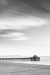 Black and white photo of a sunrise with blurred yellow clouds and calm blue water shot with long exposure to create a blurred effect.