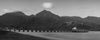 Black and white panoramic photo of Hanalei Bay Pier in Kauai Hawaii with clouds at sunrise with the Napali Coast in the background