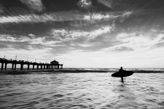 surfer at the Manhattan Beach California pier, in black and white