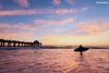 surfer at the Manhattan Beach California pier, at sunset