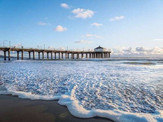 Manhattan Beach pier at low tide, sunset, with the foamy water in the foreground
