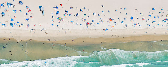 Panoramic color aerial photo of Manhattan Beach in Los Angeles with beach umbrellas, sand and the ocean