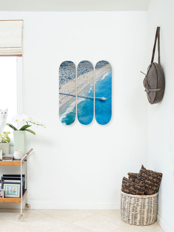 A triptych photo of Manhattan Beach pier printed on skateboards