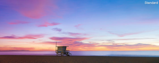 A panoramic photo of a lifeguard tower in Manhattan Beach (Los Angeles California) at sunset, with Cataline Island in the distance.