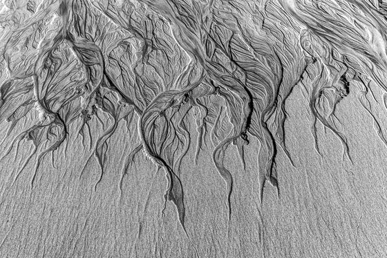 An abstract photograph of sand patterns in black and white