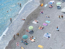 An aerial horizontal photograph of beach umbrellas and beach goers in the amalfi coast of Italy