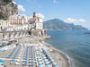 Atrani beach with sun beds and umbrellas on the Amalfi coast in Italy on a sunny day in color.