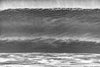 Big black and white wave before it crashes, looking like a solid wall of water