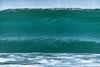 Big green wave before it crashes, looking like a solid wall of water