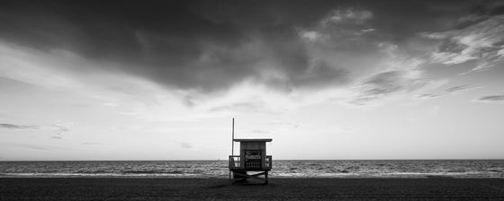 Sunset on the beach with a Los Angeles lifeguard tower in black and white.