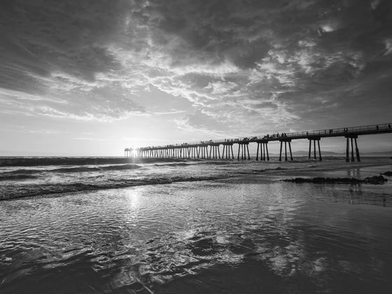 Hermosa Beach Pier (Los Angeles) photo at sunset, with the clouds reflecting in the sand, in black and white