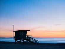  A lifeguard tower in Hermosa or Manhattan Beach California, with Catalina Island in the background, and smooth blue water and an orange and blue sky