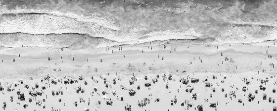 Black and white aerial photo of Manhattan Beach in Los Angeles with beach umbrellas, sand and the ocean