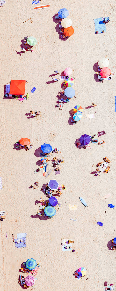 Vertical panoramic color aerial photo of Manhattan Beach in Los Angeles with red, blue, and yellow beach umbrellas
