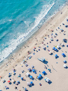  Color aerial photo of a beach in Los Angeles with beach umbrellas, a lifeguard tower and the ocean