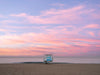 A Manhattan Beach lifeguard tower, in Los Angeles, at sunrise, with soft clouds over the Pacific Ocean