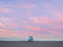  A Manhattan Beach lifeguard tower, in Los Angeles, at sunrise, with soft clouds over the Pacific Ocean