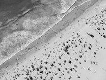  Black and white aerial photo of Manhattan Beach in Los Angeles with beach umbrellas, a lifeguard tower and the ocean