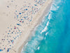 Color aerial photo of Manhattan Beach in Los Angeles with beach umbrellas, two lifeguard towers and the ocean