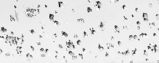 Black and white aerial photo of Manhattan Beach in Los Angeles with beach umbrellas, sand and the ocean