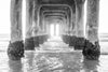 Photo of under the Manhattan Beach Pier during sunset in black and white.