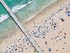 Color aerial photo of the Manhattan Beach Pier in Los Angeles with beach umbrellas, a lifeguard tower and the ocean
