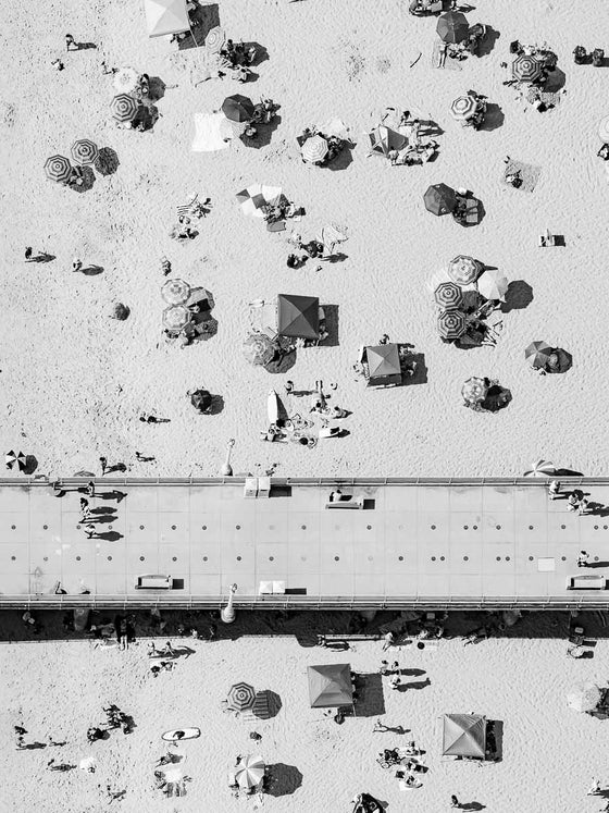 Black and white aerial photo of the Manhattan Beach Pier in Los Angeles California, with beach umbrellas