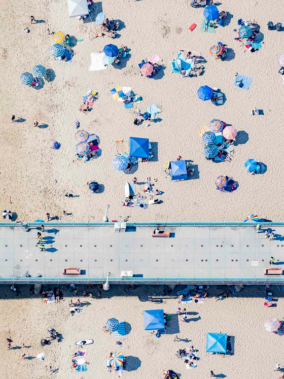 Color aerial photo of the Manhattan Beach Pier in Los Angeles California, with beach umbrellas