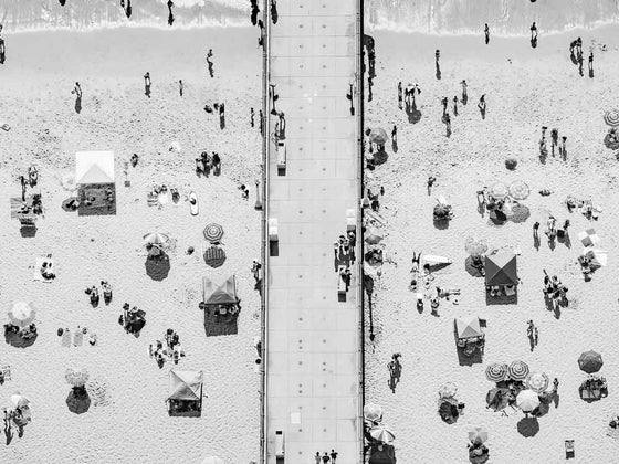 Black and white aerial photo of Manhattan Beach Pier in Los Angeles with beach umbrellas
