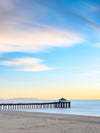 A sunrise with blurred yellow clouds and calm blue water shot with long exposure to create a blurred effect.