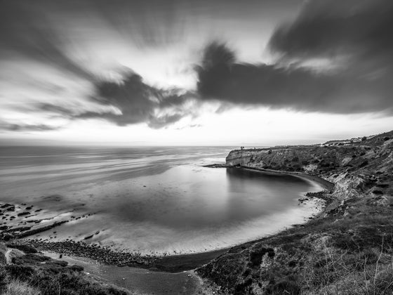 Sunset from the cliffs of Palos Verdes California, with the Pacific Ocean and Catalina Island in the distance, as a black and white long exposure photo