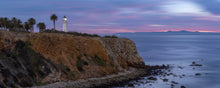  Palos Verdes, California with Point Vicente lighthouse on a cliff. Cliff on the left side of the photo and Catalina island can be seen in the background with pink clouds above it.