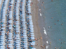  Blue and white beach umbrellas in rows on the Positano beach on the Amalfi coast in Italy in the summertime  to the left half with the ocean to the right half.