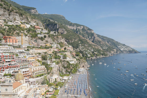 A horizontal photograph featuring the town of positano and the positano coastline in Italy