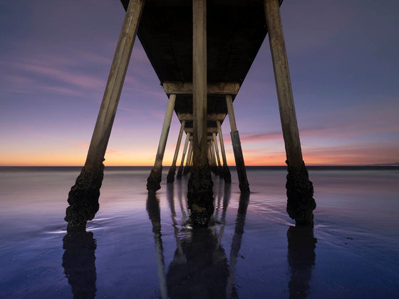 the Hermosa Beach pier at a super low tide, right after sunset, with a reflection of the clouds on the sand