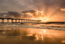  Sunset at the Hermosa Beach pier with dramatic orange and yellow clouds and sun rays breaking through them